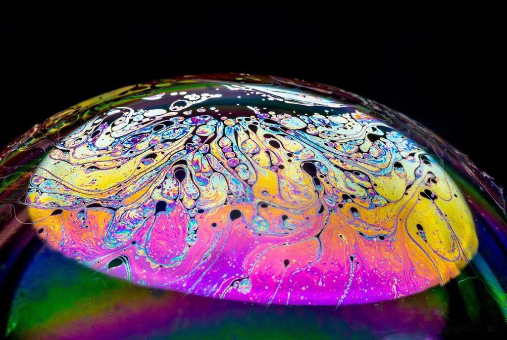 Close-up of an iridescent soap bubble with swirling colours