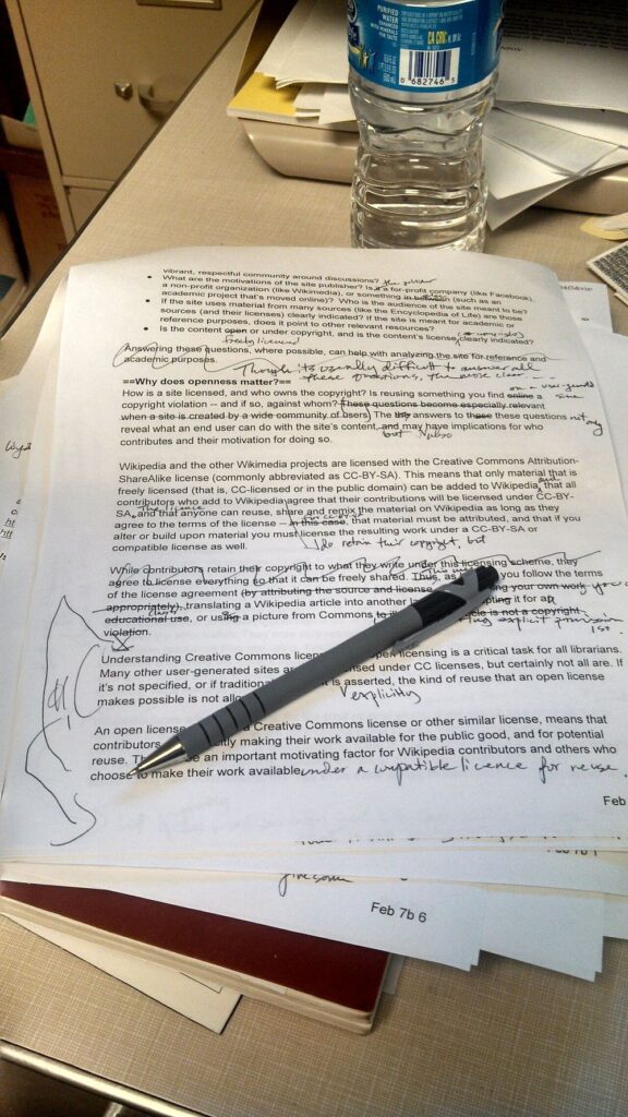 Printed manuscript page with handwritten editing marks and crossed-out text